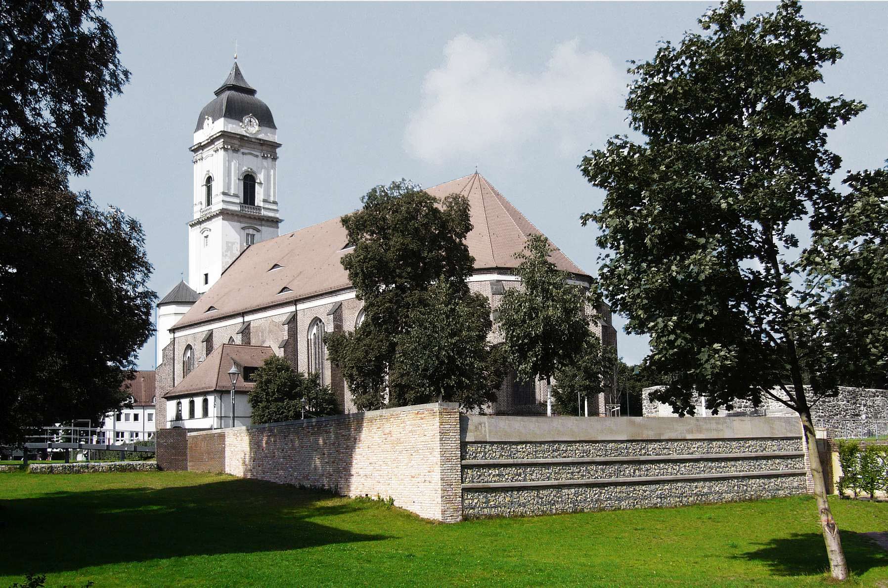 Denkmalgeschützte Kirche in Fürstenwalde mit Ummauerung, Bäumen und Wiese